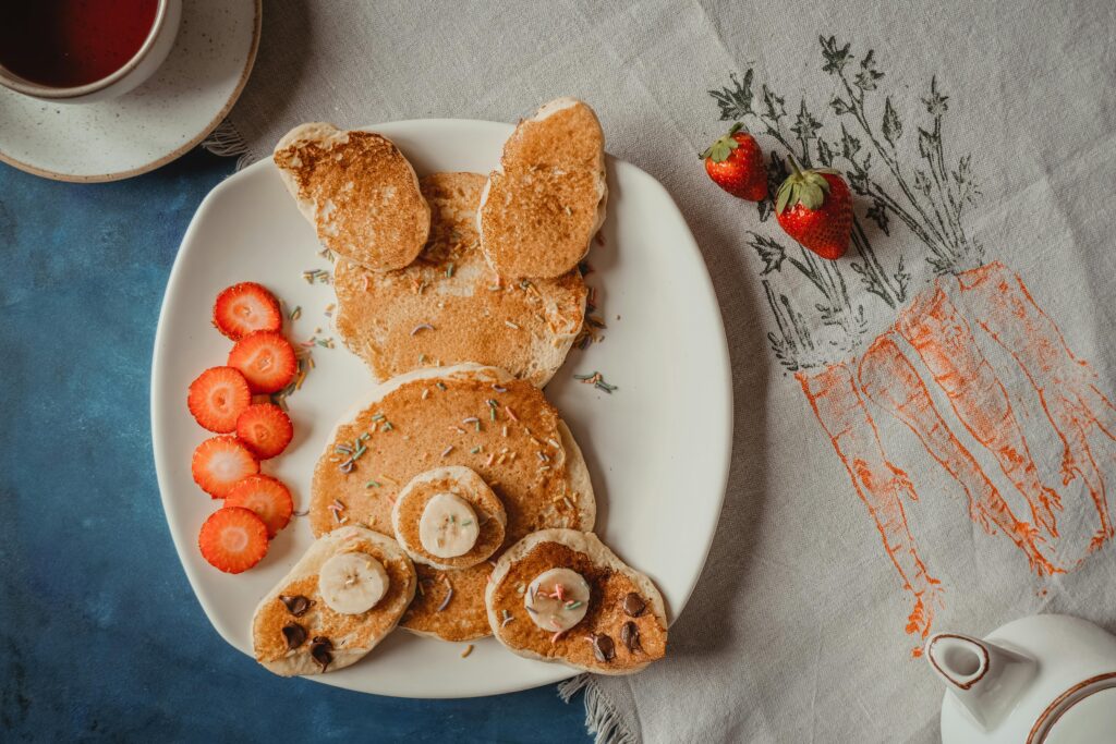 Adorable animal-shaped pancakes served with strawberries for a delightful homemade breakfast.